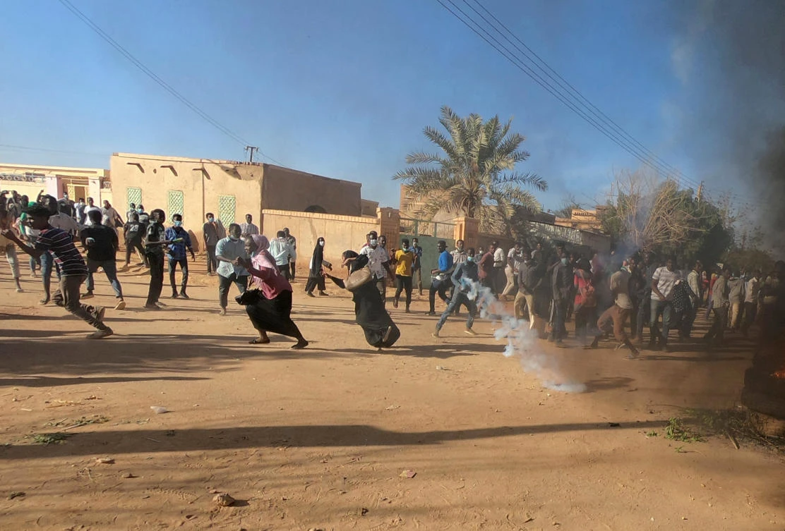 Sudanese demonstrators run from a teargas canister fired by riot policemen to disperse them as they participate in anti-government protests in Omdurman, Sudan. (File/Reuters)