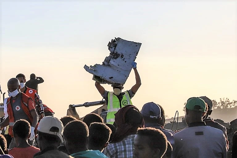 A man carries a piece of debris on his head at the crash site of a Nairobi-bound Ethiopian Airlines flight. (AFP)