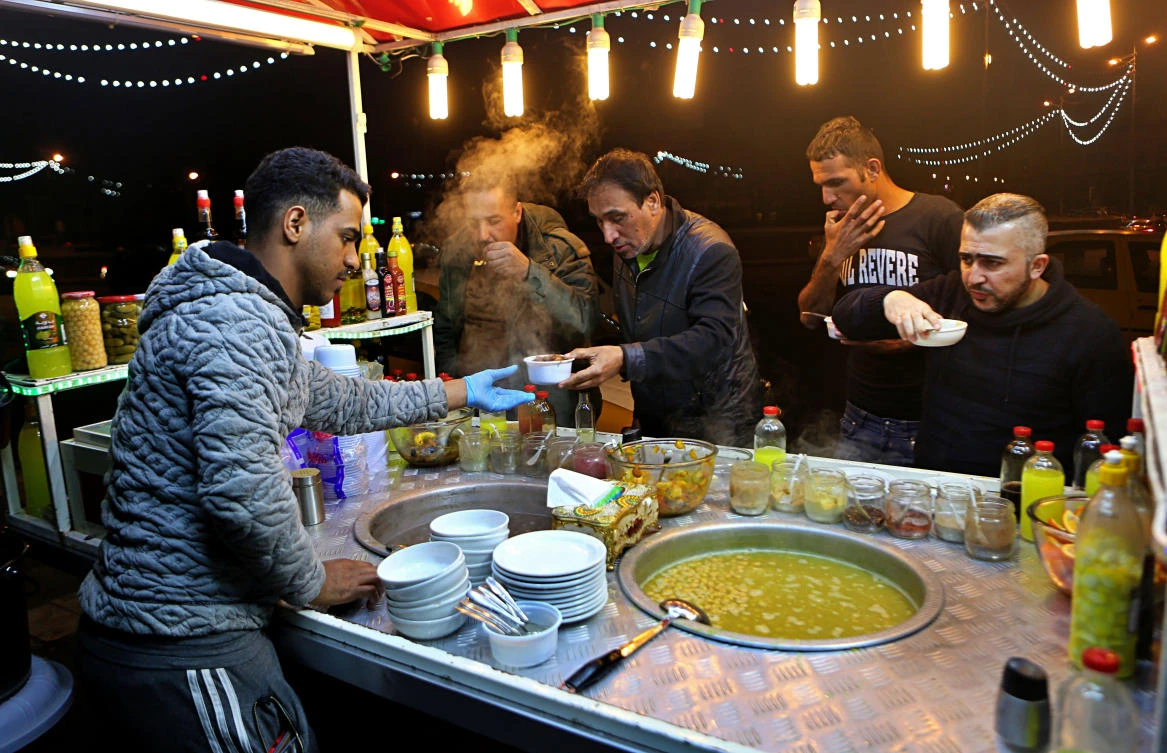 A chickpeas vendor serves customers in Tahrir Square in Baghdad, Iraq. (File/AP/Khalid Mohammed)