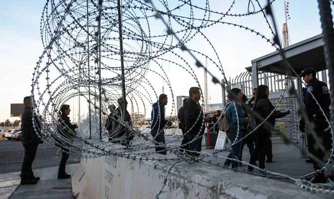 In this file photo taken on November 19, 2018 a Customs and Border Protection officer asks travelers for their visas as seen through barriers set by US authorities at San Ysidro port of Entry, at the US-Mexico border, in preparation for the arrival of a Central American migrants' caravan moving towards the United States, as seen from Tijuana, Mexico US authorities created a secret database of journalists and activists linked to a caravan of Central Americans who tried to enter the US last year from Mexico, NBC reported on March 6, 2019. (AFP)