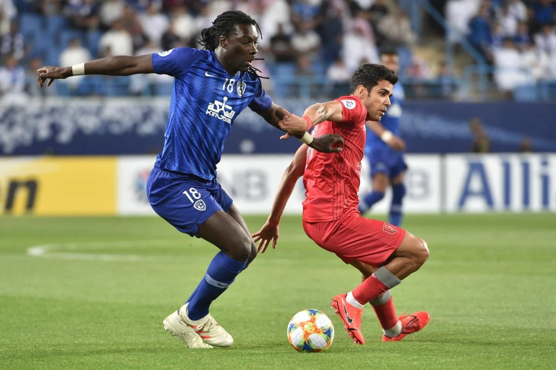 Al Hilal’s Bafetimbi Gomis, left, fights for the ball with Al-Duhail’s Ahmed Yasser during the AFC champions league Group C match between KSA’s Al Hilal and Qatar’s Al-Duhail. (AFP)