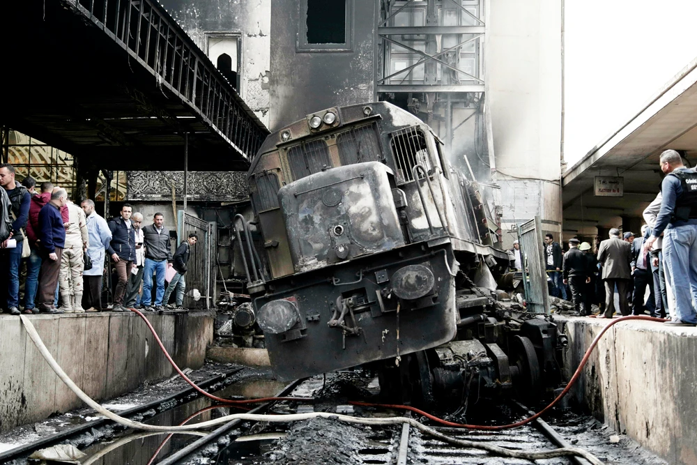A crowd surveys a damaged train inside Ramsis train station in Cairo, Egypt, on Feb. 27, 2019, hours after a fiery train collision that killed 25 people. (AP file photo)