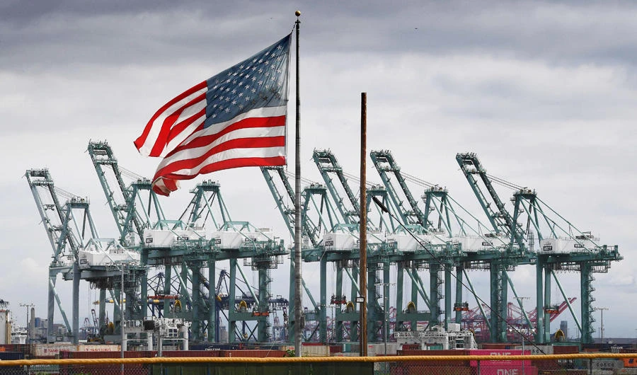 The US flag flies over shipping cranes and containers after a report said the United States and China are close to reaching a major trade deal that would see both sides lower some of the tariffs imposed during an often-bitter trade war, in Long Beach, California on March 4, 2019. (AFP / Mark Ralston)