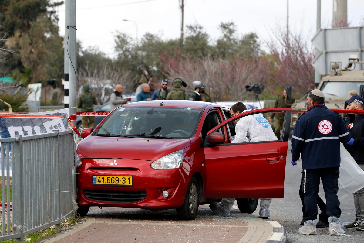 Israeli forensic workers inspect a car at the site of an attack at the junction leading to the Israeli settlement of Ariel in the occupied West Bank on Sunday, March 17, 2019. (AFP)
