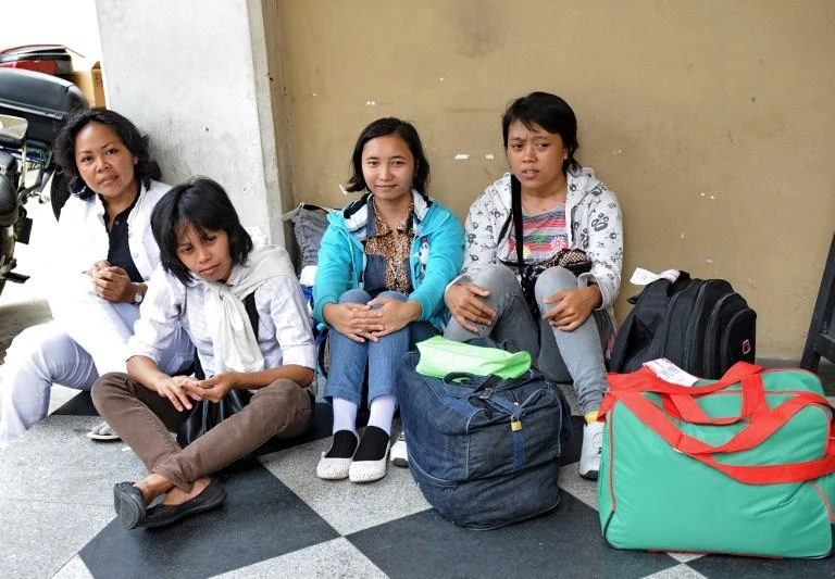 Newly arrived domestic helpers from Indonesia wait for their transportation to an agency after going through medical check in Singapore. (AFP file)