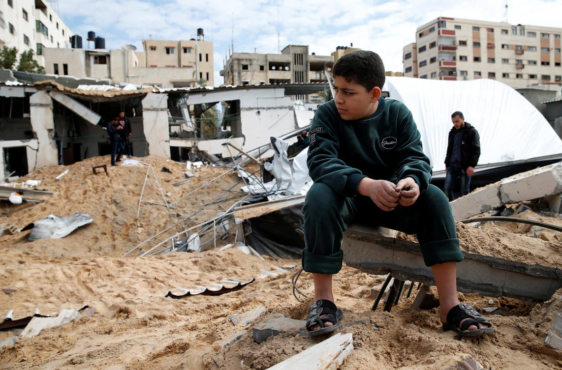 A Palestinian boy sits next to the destroyed Hamas site following Israeli air strikes, in Gaza City March 15, 2019. March 12, 2019. (Reuters)