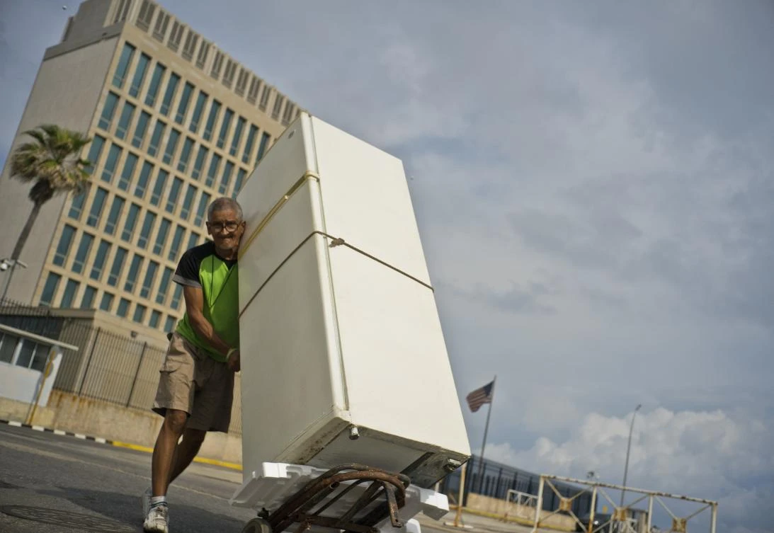 A man pushes a refrigerator on a dollie past the U.S. embassy, behind, in Havana, Cuba, Monday, March 18, 2019. (AP)
