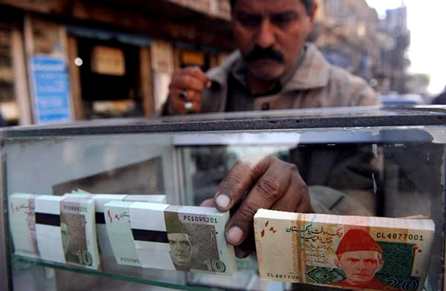 The interbank exchange rate hit all-time low of PKR 139.50 before closing at PKR 139.39 against US dollar that closed at PKR 139.40 on Monday. However, the currency lost in open market to PKR 139.70 against greenback. (AFP/photo)
