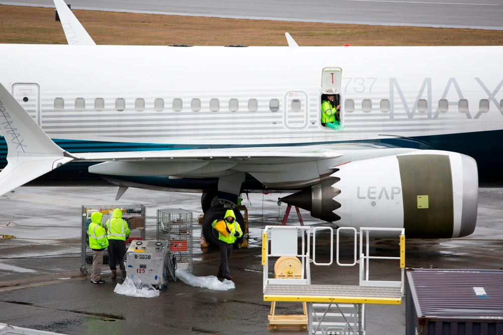 Workers are pictured next to a Boeing 737 MAX 9 airplane on the tarmac at the Boeing Renton Factory in Renton, Washington, on March 12, 2019. (AFP / Jason Redmond)