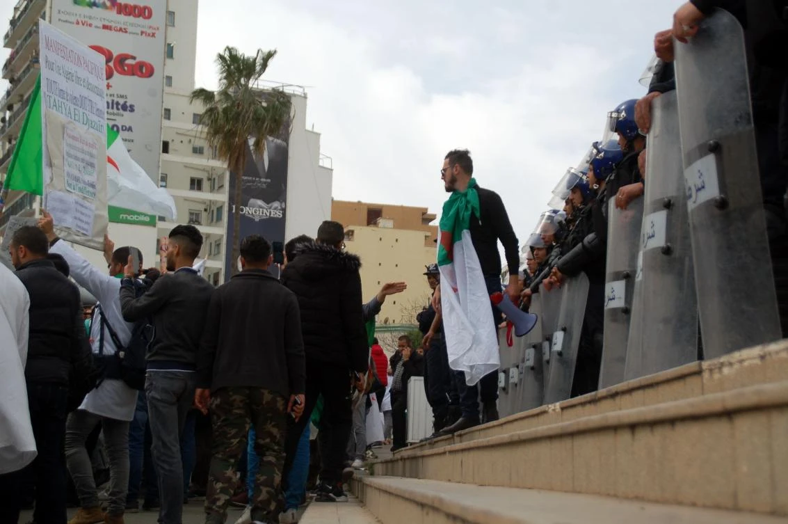 Algerian students raise signs and shout slogans in front of anti-riot police during a rally against President Bouteflika in the northern coastal city of Oran on March 19, 2019. (AFP)