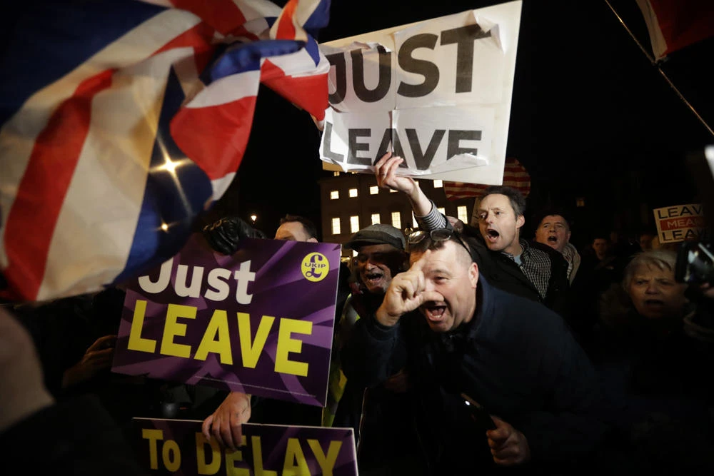 Pro-Brexit supporters shout at an anti-Brexit supporter opposite the Houses of Parliament in London on March 14, 2019. (AP Photo/Matt Dunham)