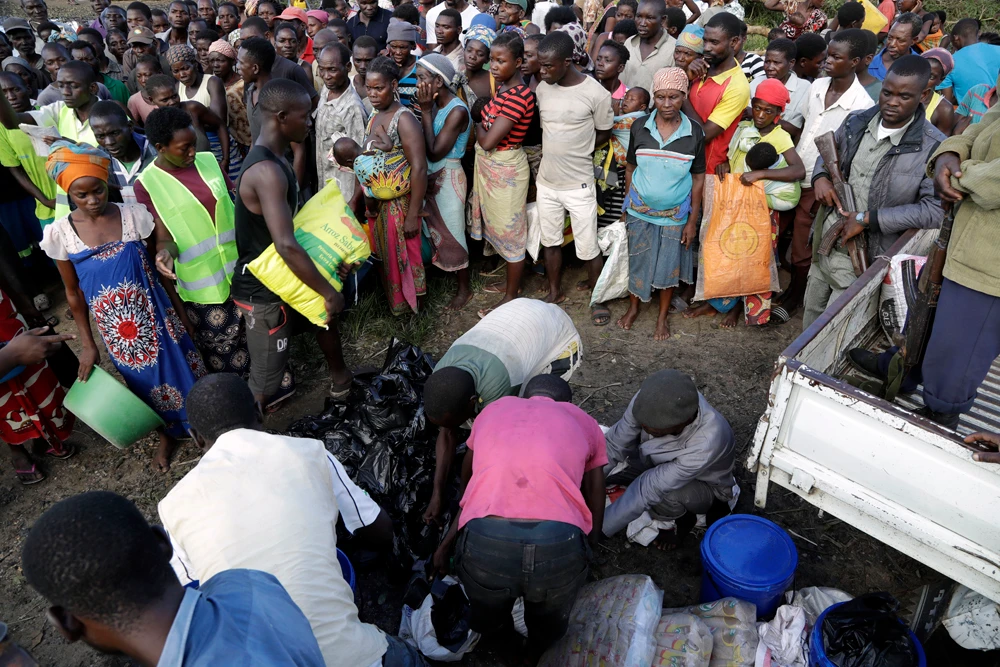 Mozambicans stands in a queue to receive food from the World Food Programme in Nhamatanda, about 100 kilometers west of Beira, on March 21, 2019. (AP Photo/Themba Hadebe)