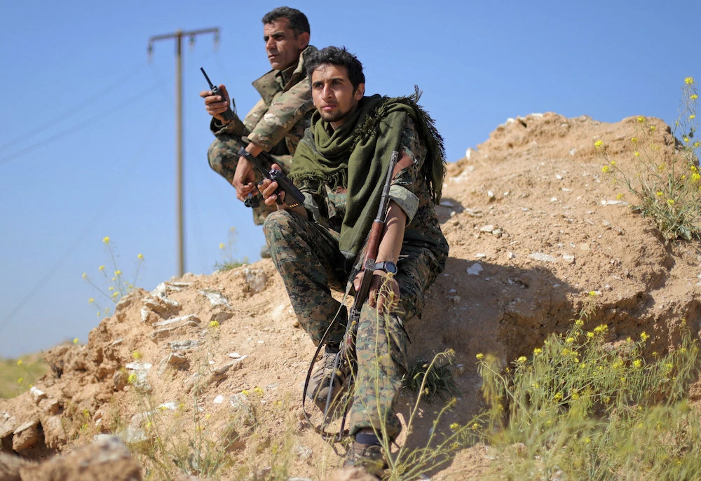 Fighters from the Syrian Democratic Forces (SDF) hold walkie-talkies in the village of Baghouz, Daesh's last holdout, which the US said has now been eliminated. (Reuters)