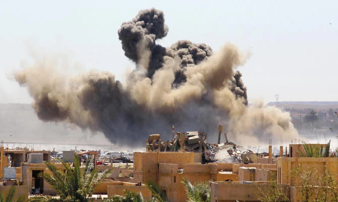 Smoke rises from the last besieged neighborhood in the village of Baghouz, Syria, after US-led airstrikes pound the area. (File/Reuters)