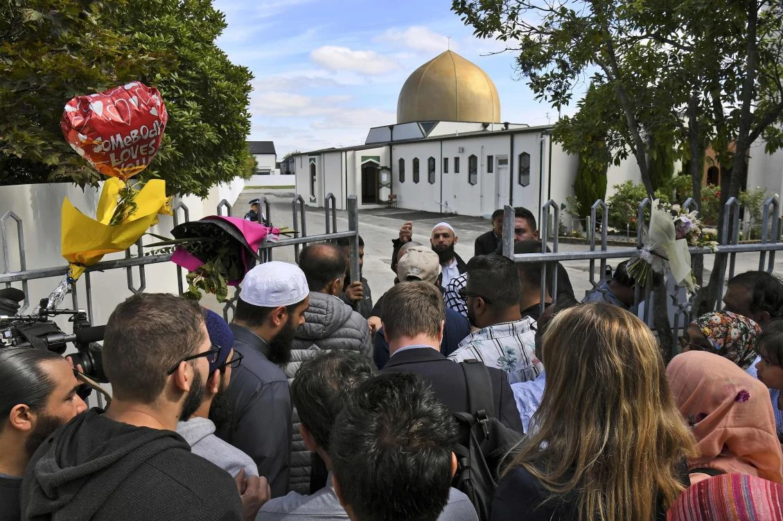 People including members of the local Muslim community queue at the gates of the Al Noor mosque after is was reopened in Christchurch on March 23, 2019. (AFP)