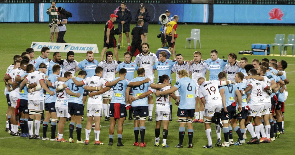 The Waratahs and the Crusaders Super Rugby teams join together before their game for a minute silence for the victims of the New Zeland mass shootings in Sydney, Australia, Saturday, March 23, 2019. (AP Photo/Rick Rycroft)