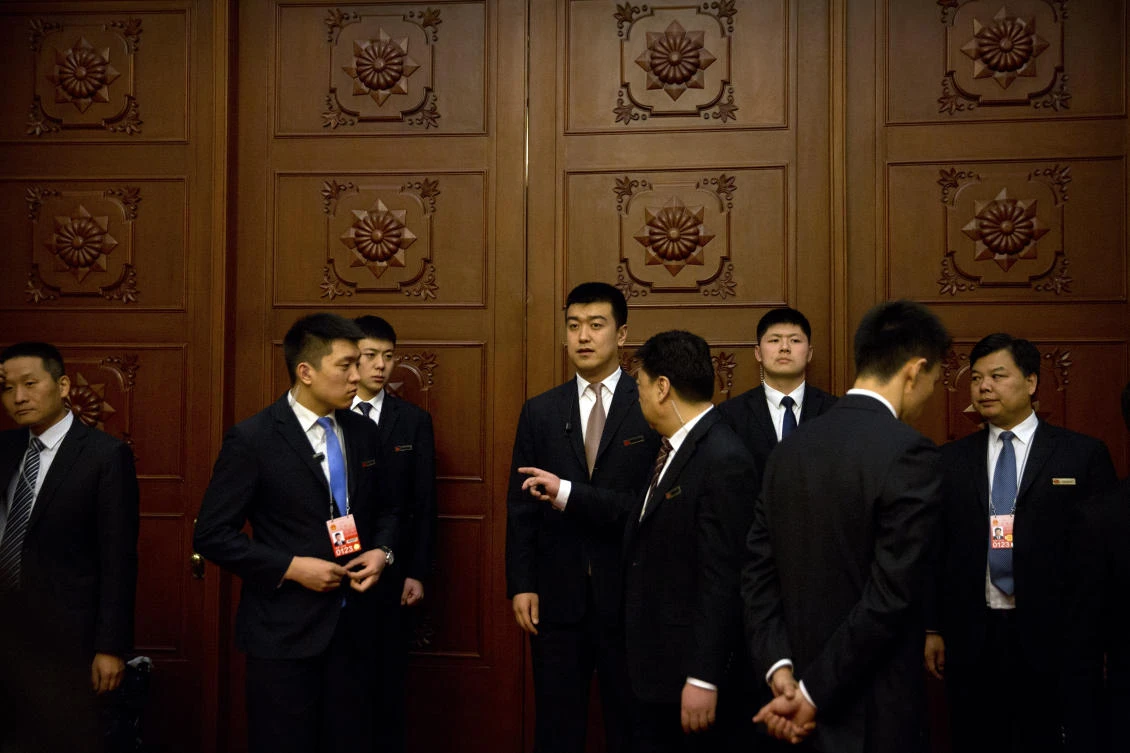 Officials stand outside closed doors as delegates from China’s Xinjiang Uighur Autonomous Region have a group discussion meeting on the sidelines of China’s National People’s Congress (NPC) at the Great Hall of the People in Beijing on March 12, 2019. (File/AP)
