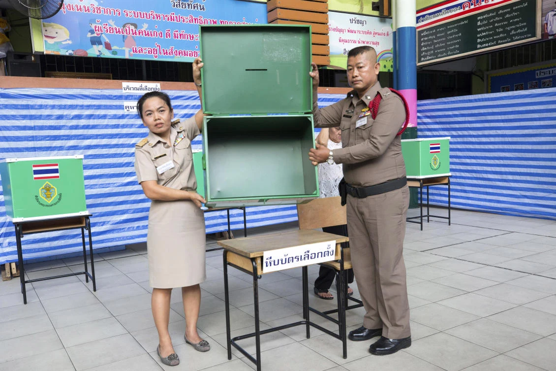 Thai officials display an empty ballot box before the start of voting at a polling station in Bangkok on Sunday, March 24, 2019. (AP)
