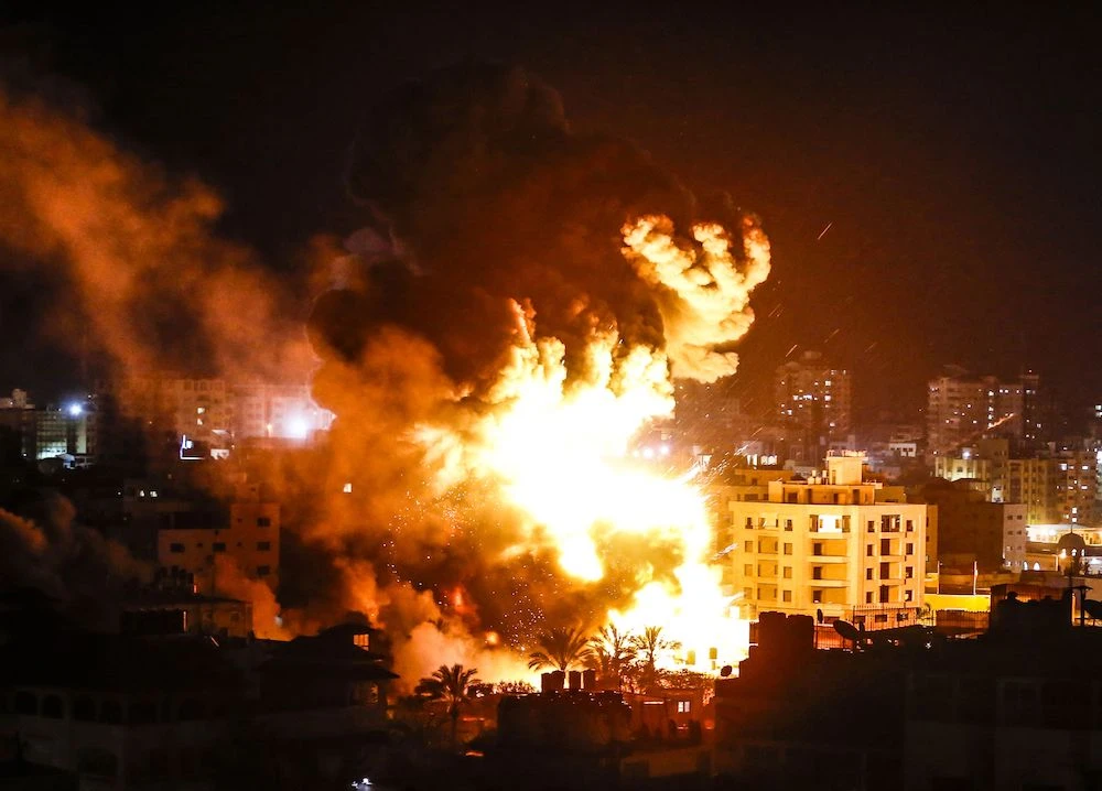 Fire and smoke below above buildings in Gaza City during reported Israeli strikes on March 25, 2019. (AFP)