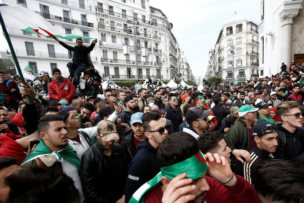 People carry national flags during a protest calling on President Abdelaziz Bouteflika to quit, in Algiers on Tuesday. (Reuters)