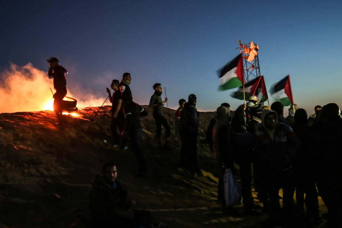 Palestinian protesters take part in a night demonstration near the fence along the border with Israel, in Rafah in the southern Gaza Strip, on March 19, 2019. (AFP/Said Khatib)