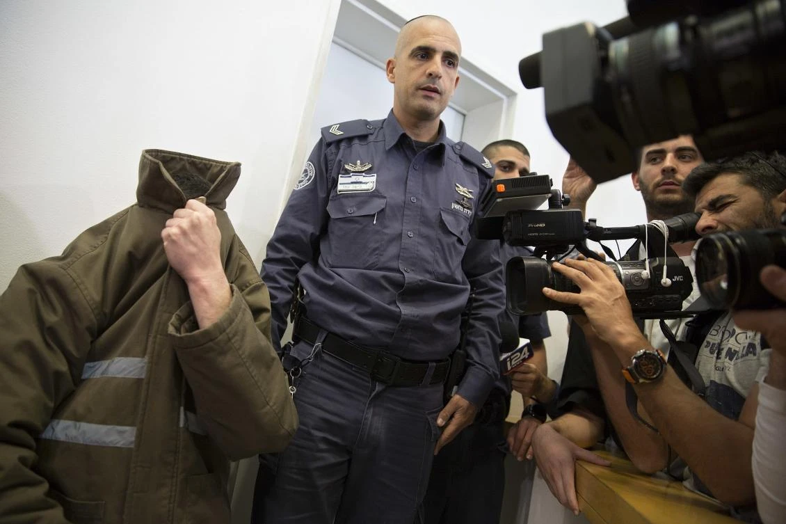 French consulate worker Romain Franck, an employee of France’s Consulate in Jerusalem, covers his face during a hearing at the district court in the southern Israeli city of Beersheba. (AP Photo)