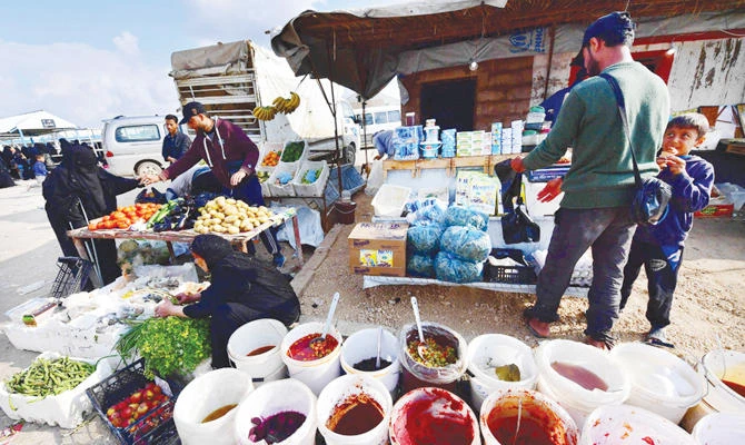 Street vendors sell pickles and vegetables in the market of Al-Hol Camp, northeastern Syria. (AFP)
