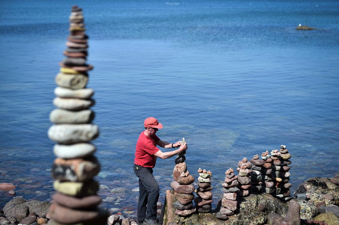 A competitor creates their sculpture in the European Stone Stacking Championships 2019 in Dunbar, Scotland, on April 21, 2019. The European Stone Stacking Championships are Europe’s largest championships for all Stone Stacking and Rock Balancing artists and practitioners. Stackers compete in four competitions creating sculptures using stones and balancing them using only the force of gravity. The overall winner receives a trip to llano Earth Art Festival and World Stone Balancing competition 2020. / AFP / Andy Buchanan