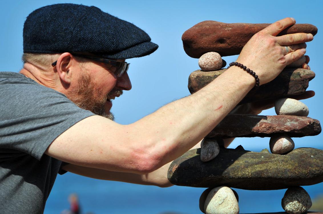 Laurence Winram from Edinburgh competes in the European Stone Stacking Championships 2019 in Dunbar, Scotland, on April 21, 2019. The European Stone Stacking Championships are Europe’s largest championships for all Stone Stacking and Rock Balancing artists and practitioners. Stackers compete in four competitions creating sculptures using stones and balancing them using only the force of gravity. The overall winner receives a trip to llano Earth Art Festival and World Stone Balancing competition 2020. / AFP / Andy Buchanan