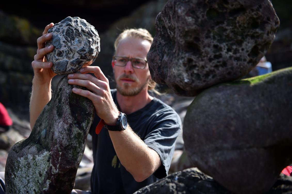 Philip Wachmann from Austria competes in the European Stone Stacking Championships 2019 in Dunbar, Scotland, on April 21, 2019. The European Stone Stacking Championships are Europe’s largest championships for all Stone Stacking and Rock Balancing artists and practitioners. Stackers compete in four competitions creating sculptures using stones and balancing them using only the force of gravity. The overall winner receives a trip to llano Earth Art Festival and World Stone Balancing competition 2020. / AFP / Andy Buchanan