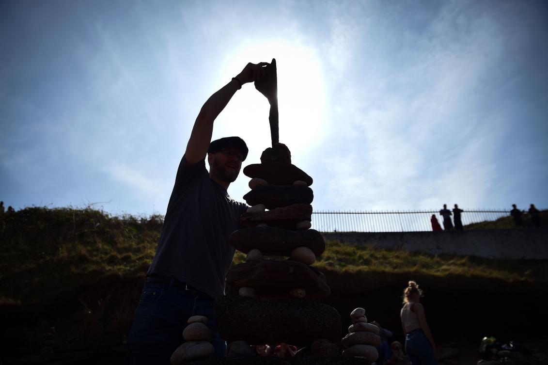 Laurence Winram from Edinburgh competes in the European Stone Stacking Championships 2019 in Dunbar, Scotland, on April 21, 2019. The European Stone Stacking Championships are Europe’s largest championships for all Stone Stacking and Rock Balancing artists and practitioners. Stackers compete in four competitions creating sculptures using stones and balancing them using only the force of gravity. The overall winner receives a trip to llano Earth Art Festival and World Stone Balancing competition 2020. / AFP / Andy Buchanan