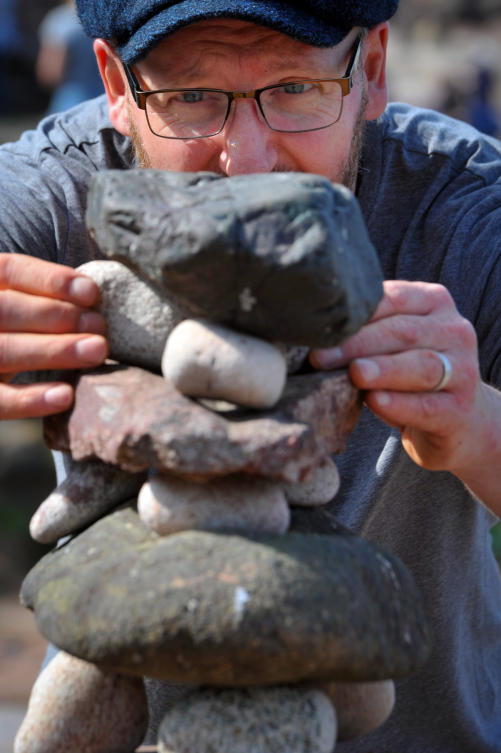 Laurence Winram from Edinburgh competes in the European Stone Stacking Championships 2019 in Dunbar, Scotland, on April 21, 2019. The European Stone Stacking Championships are Europe’s largest championships for all Stone Stacking and Rock Balancing artists and practitioners. Stackers compete in four competitions creating sculptures using stones and balancing them using only the force of gravity. The overall winner receives a trip to llano Earth Art Festival and World Stone Balancing competition 2020. / AFP / Andy Buchanan