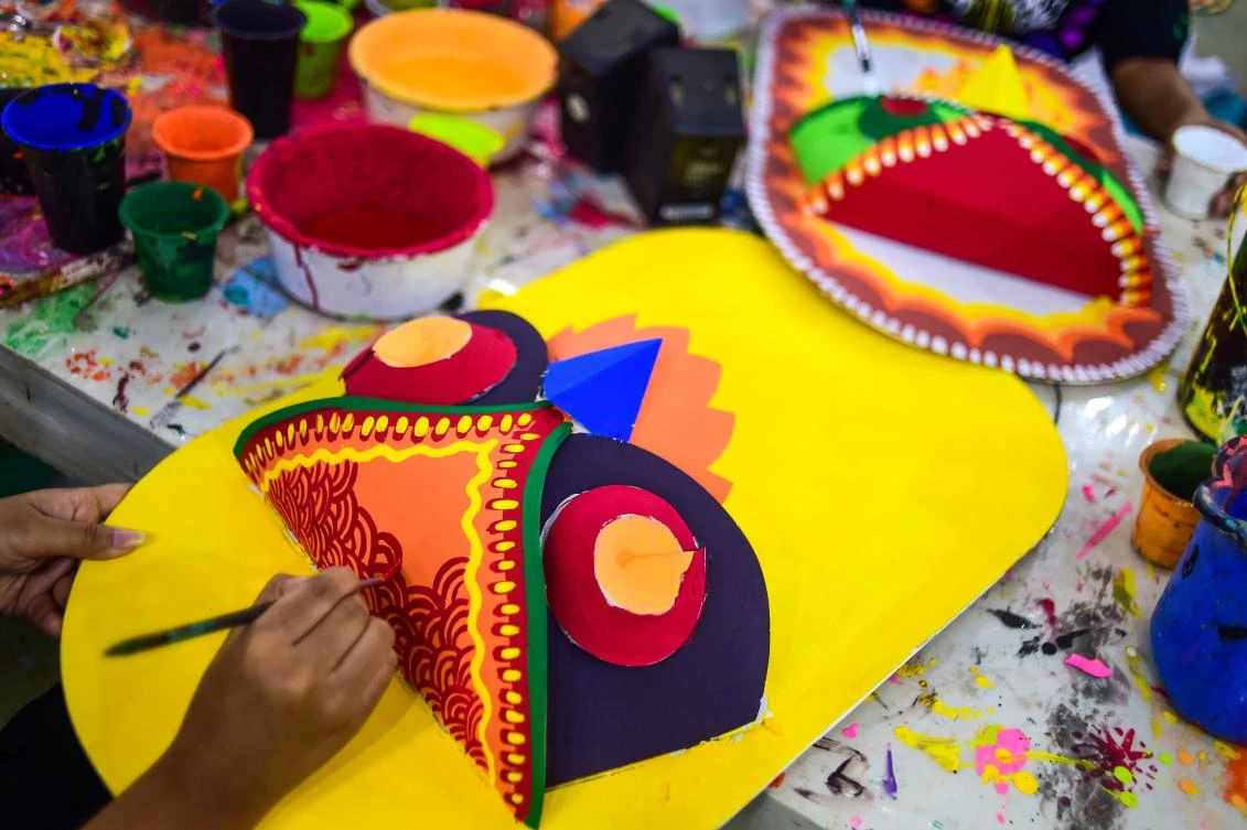 A Bangladeshi student of Dhaka University Art Institute paints a mask to sell as a part of Bengali New Year preparations in Dhaka on April 7, 2019. The Bengali calendar is solar, with the year beginning on Pohela Boishakh, which falls on April 14 this year, in Bangladesh. / AFP / Munir UZ ZAMAN