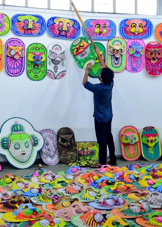 A Bangladeshi student of the Art Institute of Dhaka University hangs colourful masks for sale in preparation for the Bengali New Year celebration, in Dhaka on April 7, 2019. The Bengali calendar is solar, with the year beginning on Pohela Boishakh, which falls on April 14 this year, in Bangladesh. / AFP / Munir UZ ZAMAN