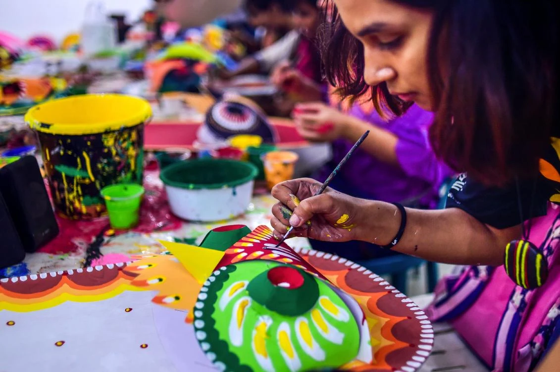 A Bangladeshi student of Dhaka University Art Institute paints a mask to sell as a part of Bengali New Year preparations in Dhaka on April 7, 2019. The Bengali calendar is solar, with the year beginning on Pohela Boishakh, which falls on April 14 this year, in Bangladesh. / AFP / Munir UZ ZAMAN