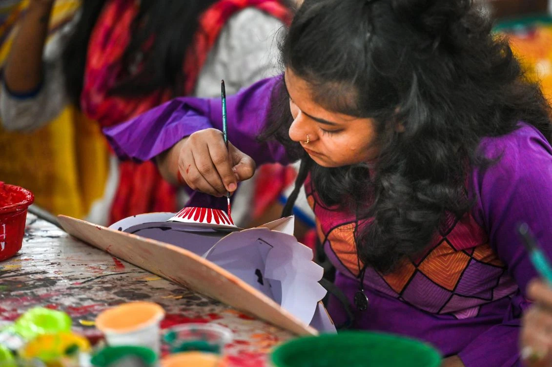 A Bangladeshi student of Dhaka University Art Institute paints a mask to sell as a part of Bengali New Year preparations in Dhaka on April 7, 2019. The Bengali calendar is solar, with the year beginning on Pohela Boishakh, which falls on April 14 this year, in Bangladesh. / AFP / Munir UZ ZAMAN