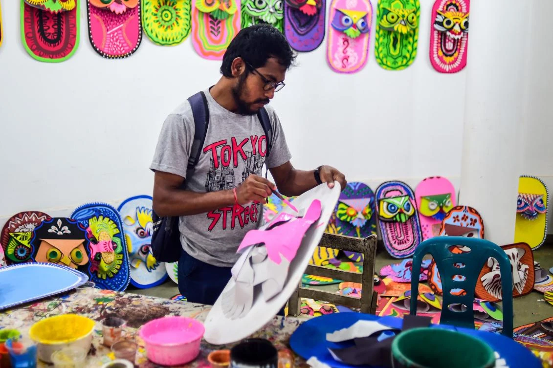 A Bangladeshi student of Dhaka University Art Institute paints a mask to sell as a part of Bengali New Year preparations in Dhaka on April 7, 2019. The Bengali calendar is solar, with the year beginning on Pohela Boishakh, which falls on April 14 this year, in Bangladesh. / AFP / Munir UZ ZAMAN