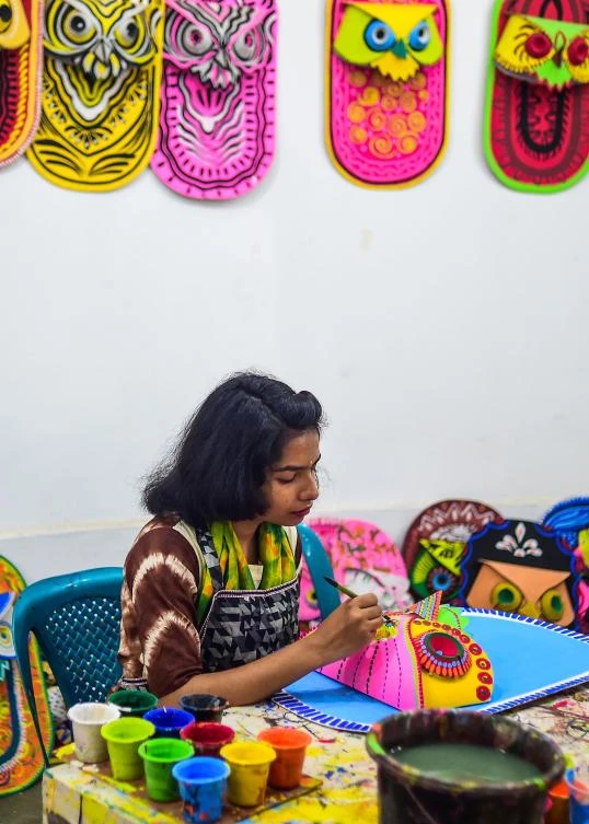 A Bangladeshi student of Dhaka University Art Institute paints a mask to sell as a part of Bengali New Year preparations in Dhaka on April 7, 2019. The Bengali calendar is solar, with the year beginning on Pohela Boishakh, which falls on April 14 this year, in Bangladesh. / AFP / Munir UZ ZAMAN