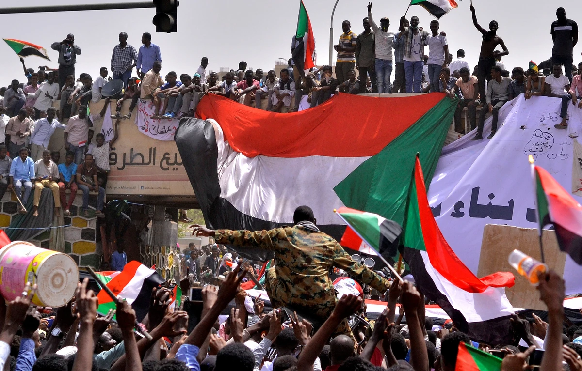 A military officer is carried by the crowd as demonstrators chant slogans and carry their national flags, after Sudan's Defense Minister Awad Mohamed Ahmed Ibn Auf said that President Omar al-Bashir had been detained "in a safe place" and that a military council would run the country for a two-year transitional period. (Reuters)