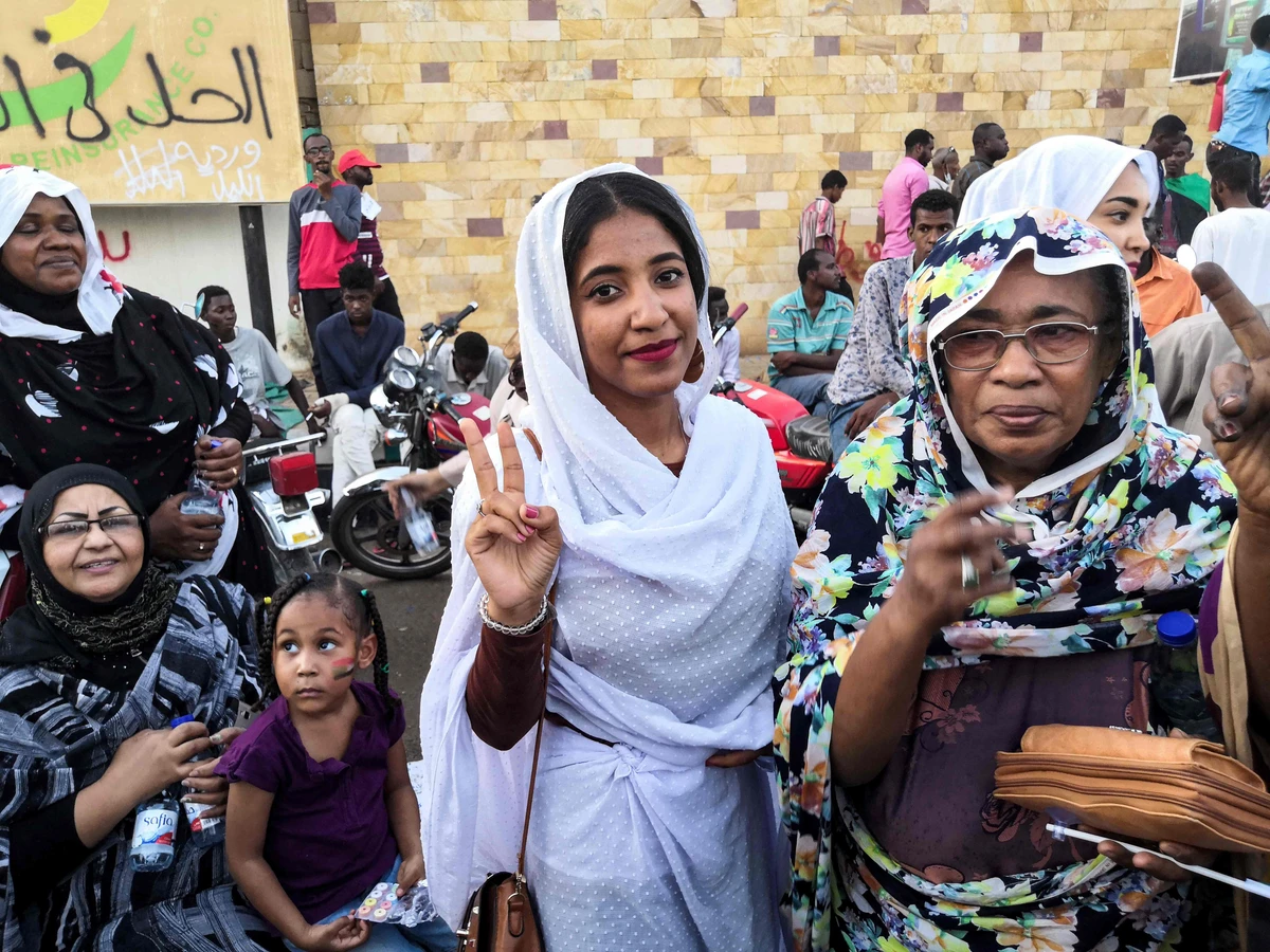 Alaa Salah flashes the victory gesture as she poses for a picture during a demonstration. (AFP)