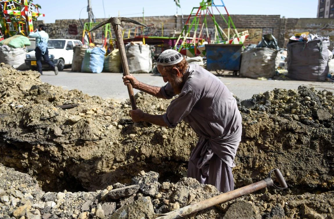 A Pakistani labourer works on a roadside digging soil in Karachi on April 30, 2019, on the eve of the International Labour Day celebrated on May 1. / AFP / RIZWAN TABASSUM