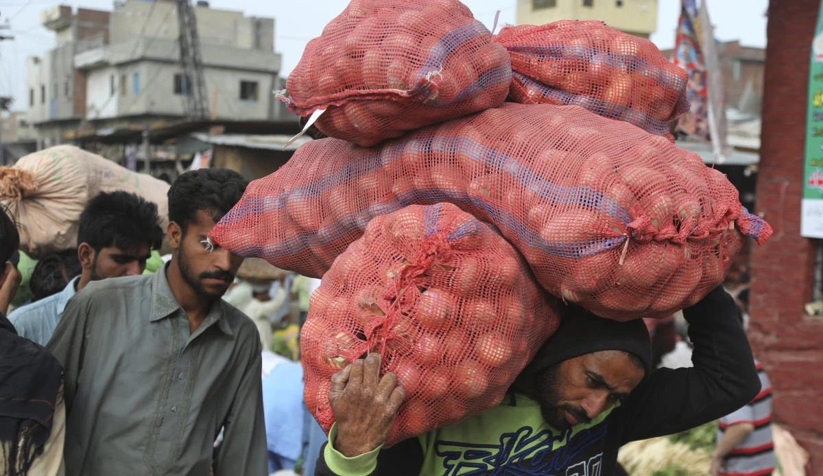 Pakistani laborers carry sacks at a market in Lahore, Pakistan, Tuesday, April 30, 2019. Pakistan will observe the Labor Day on Wednesday along with other nations worldwide. (AP Photo/K.M. Chaudary)