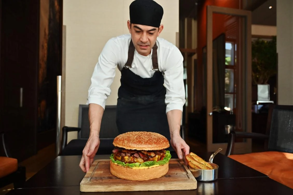 Patrick Shimada, the chef de cuisine at The Oak Door of the Grand Hyatt Tokyo hotel poses with a 3kgs burger in Tokyo on April 1, 2019. (AFP/Charly Triballeau)
