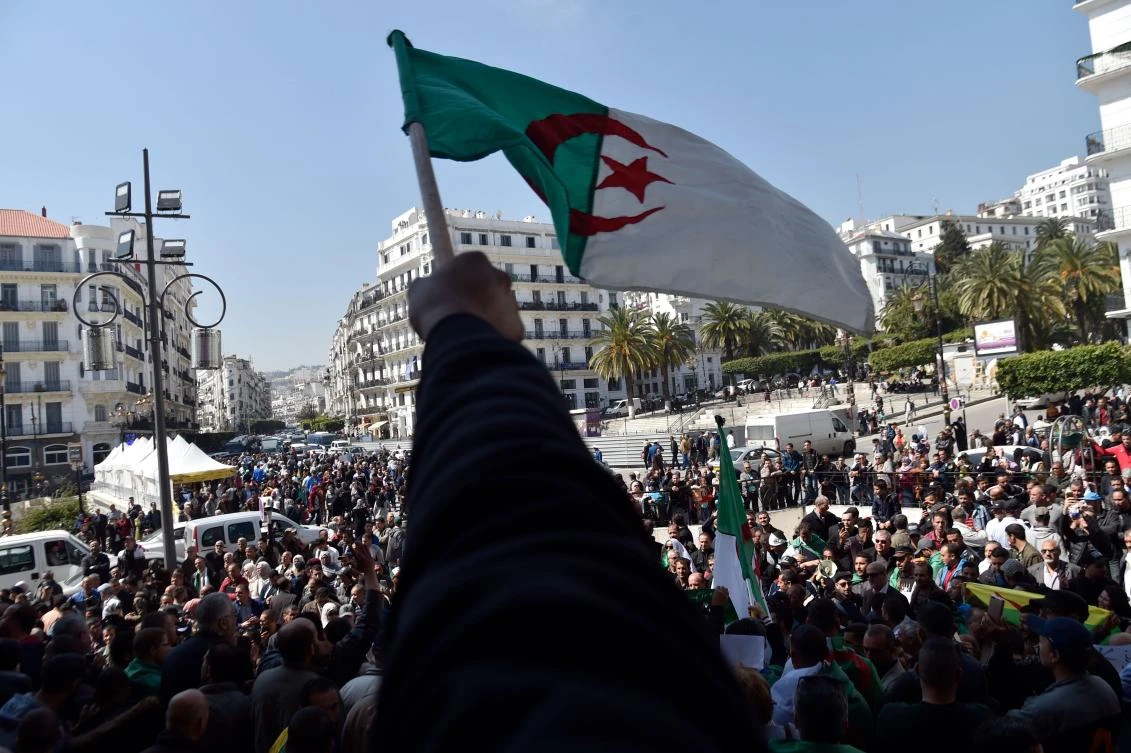 Algerians wave the national flag as they demonstrate to demand sweeping change to the country's whole political system, in Algiers on April 3, 2019. (AFP)