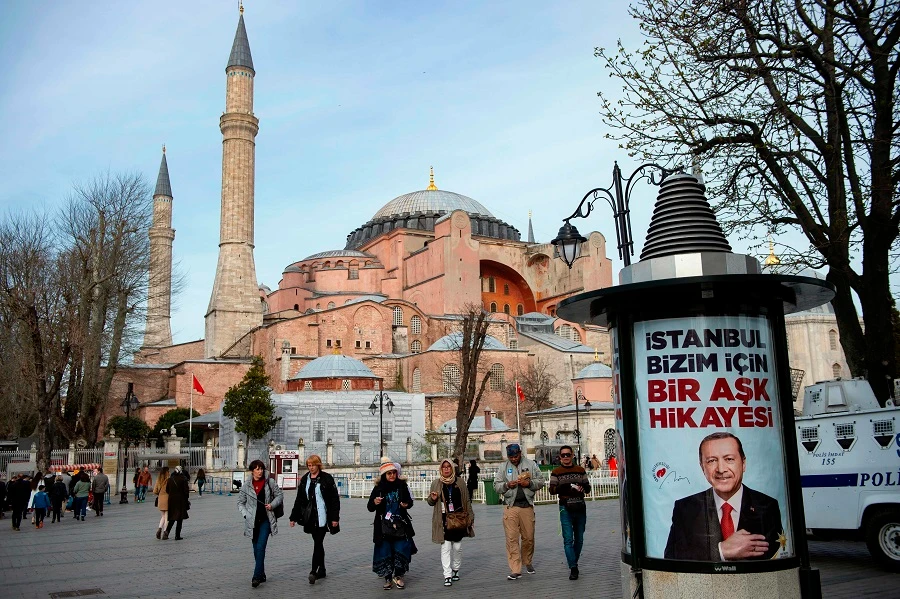 People walk past an election poster of the Turkish President Recep Tayyip Erdogan, reading “Istanbul is a love story for us,” in front of the Hagia Sophia museum in Istanbul, on March 26, 2019, ahead of March 31 local elections. (File/AFP)
