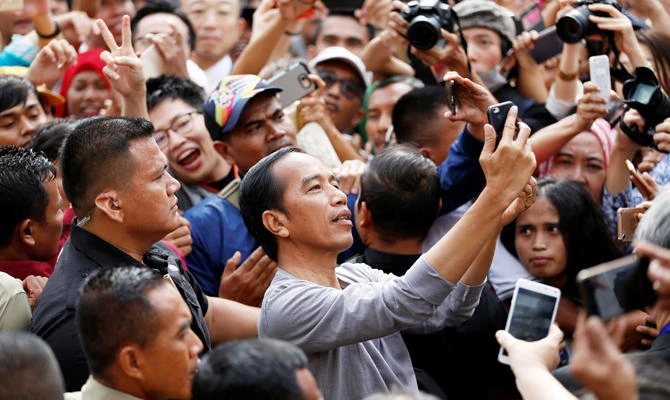 Indonesia's President Joko Widodo (C) takes selfie pictures during the Jakarta Mass Rapid Transit (MRT) first-phase launching in Jakarta, Indonesia, March 24, 2019. (REUTERS)