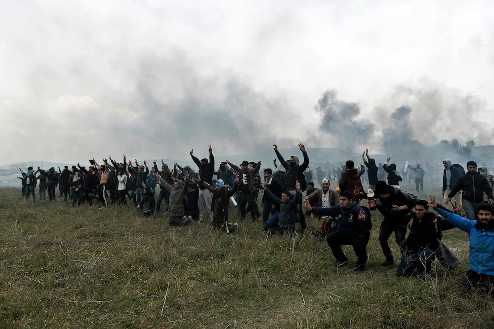 Migrants shout slogans during clashes with Greek riot police outside of a refugee camp in Diavata, a west suburb of Thessaloniki, where migrants gathered on April 6, 2019.