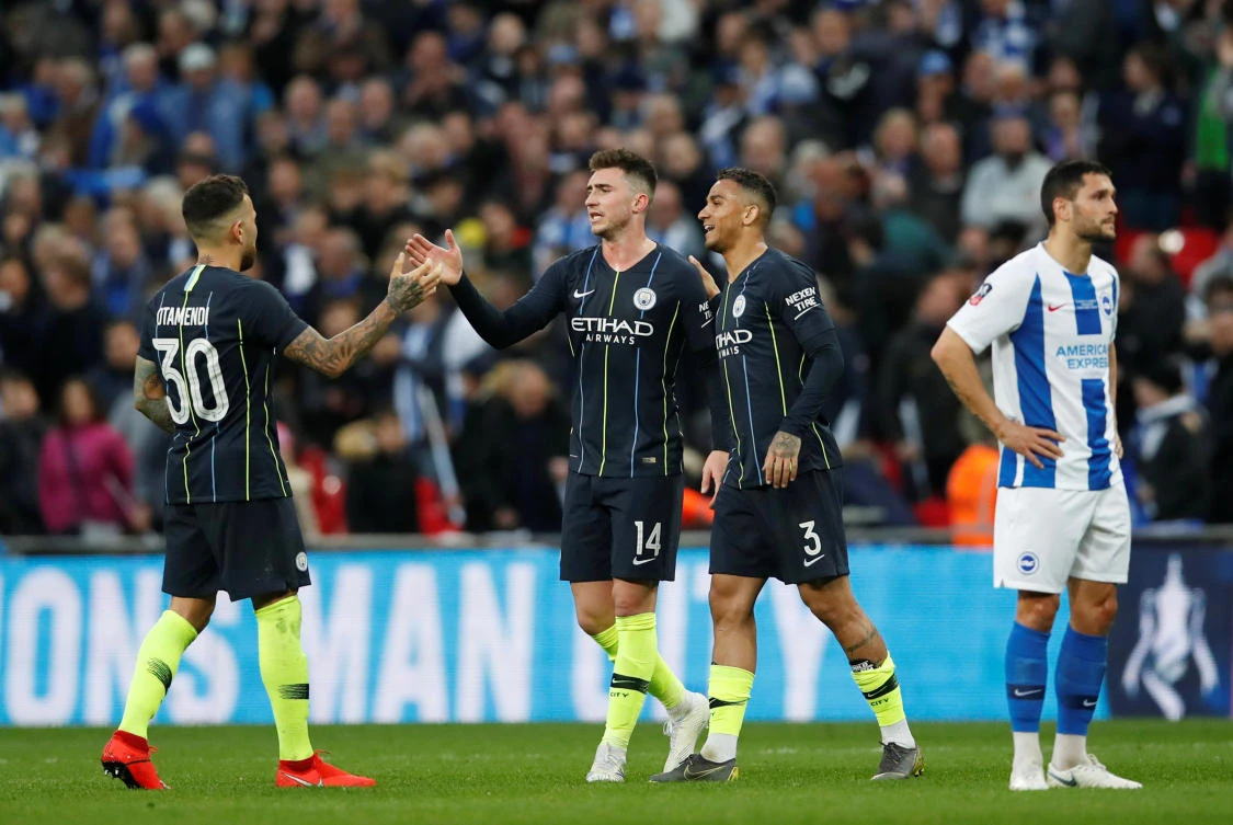 Manchester City's Nicolas Otamendi, Danilo and Aymeric Laporte celebrate after the match as Brighton's Florin Andone looks dejected during the Wembley FA Cup semifinal. (Reuters)
