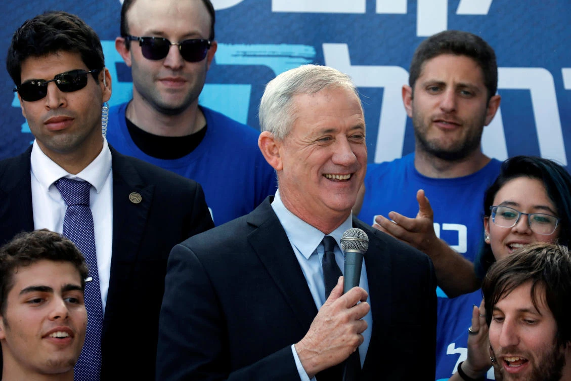 Benny Gantz, leader of the Blue and White political alliance, smiles while giving a statement to the media as supporters stand behind him outside party headquarters in Tel Aviv, Israel. (Reuters)