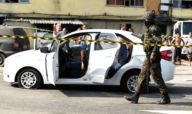 An Army soldier walks near a car in which a man was killed during a military operation, in Rio de Janeiro, Brazil April 7, 2019. (REUTERS)